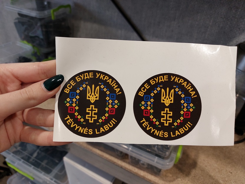Наліпки, які майстер Андрій приклеює на відремонтовані дрони, на знак подяки литовському народу. На наліпці надруковано «Все буде Україна!» та напис литовською, який у перекладі означає «Заради Батьківщини!». Наліпки, які майстер Андрій приклеює на відремонтовані дрони, на знак подяки литовському народу. На наліпці надруковано «Все буде Україна!» та напис литовською, який у перекладі означає «Заради Батьківщини!».